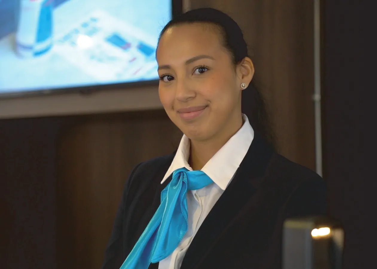 Addetta al front office in divisa, alla reception di un hotel